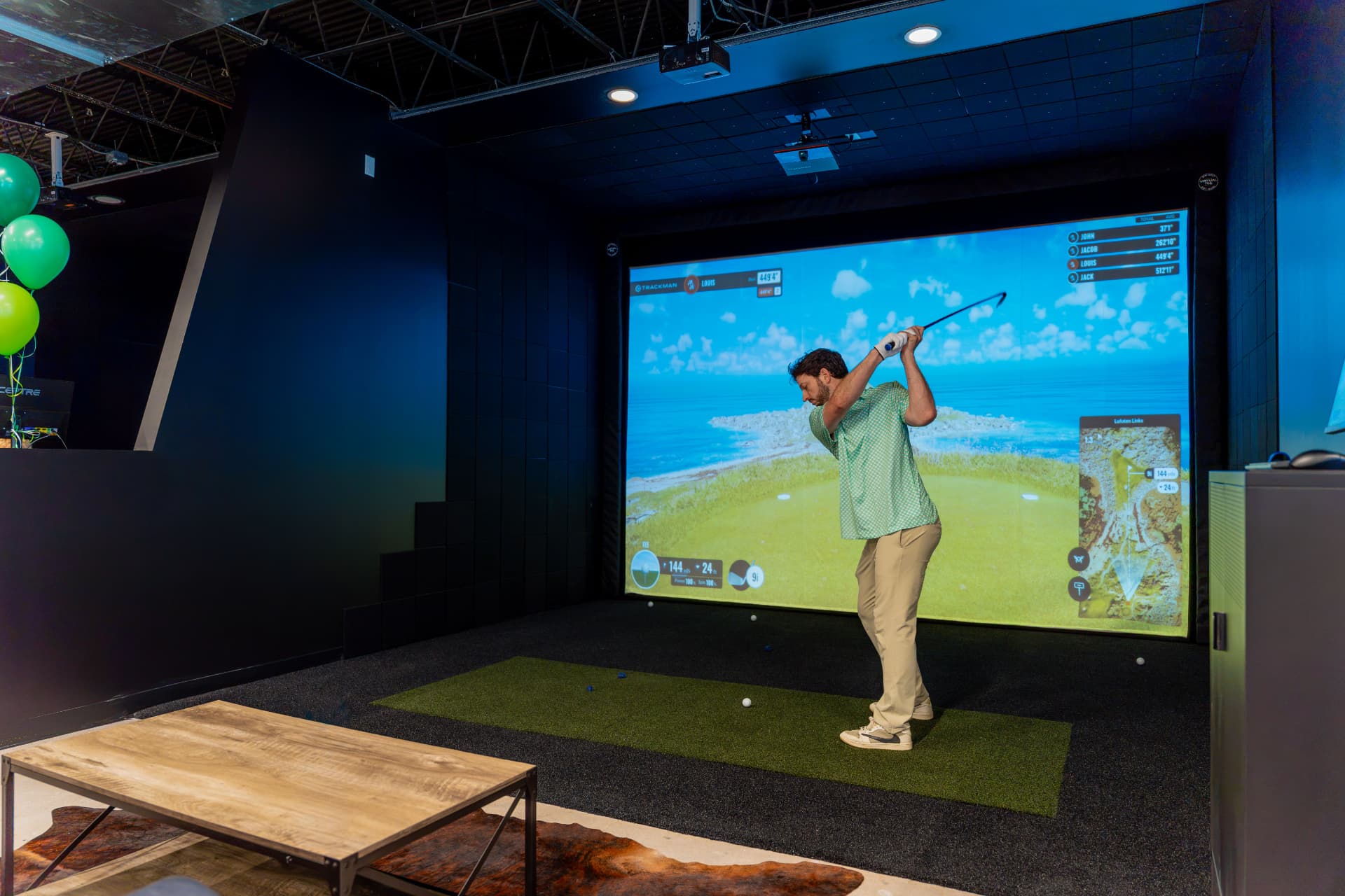 Golfer swinging in a TrackMan bay at The Golf Workshop
